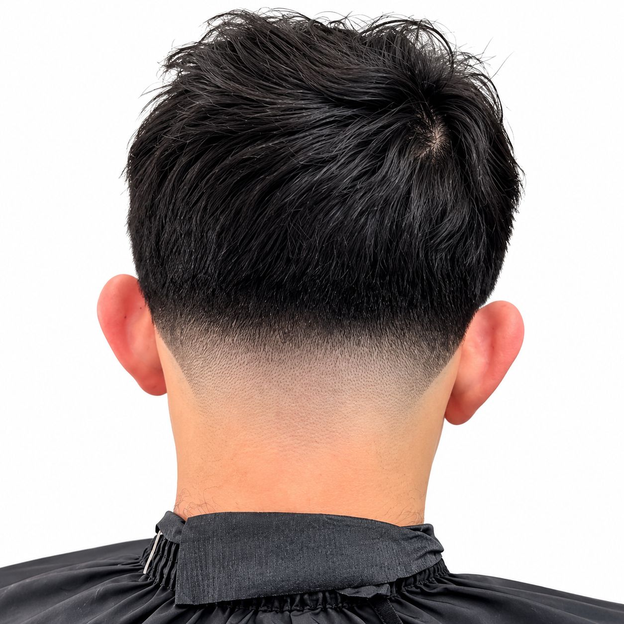 High taper at the neckline under a textured top, seen from behind