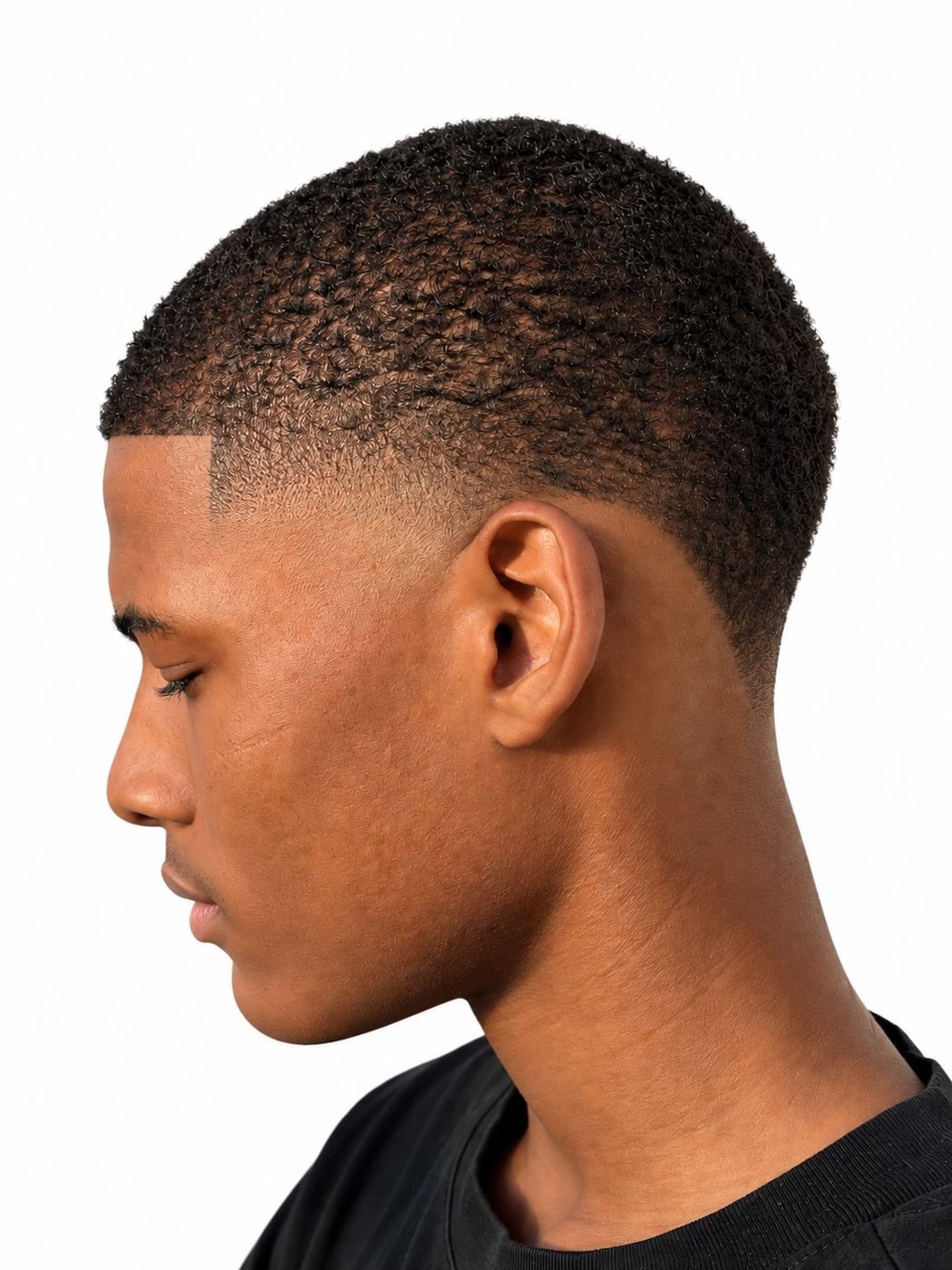 High taper on a short natural-texture cut with a crisp line-up, left profile